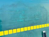 painting on the side of a green airplane with a yellow strip