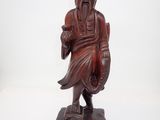 l'image d'une statue en bois représentant un homme avec un chapeau sur la tête