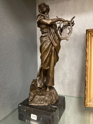 a statue of a woman holding a basket on a glass table