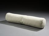a long pillow that is sitting on the floor