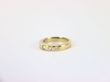 gros plan d'une bague en or ornée de trois diamants