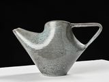gray vase on a white table with a black background