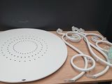 a white plate with wires and a charger on a wooden table