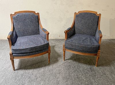 une paire de fauteuils rembourrés bleus dans une pièce, avec un mur en arrière-plan