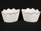 two white bowls with blue lines on them on a black background