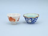 une paire de petits bols bleus et blancs ornés de fleurs orange