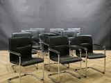 six fauteuils en cuir noir alignés sur un parquet