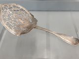une cuillère en argent posée sur une table en verre