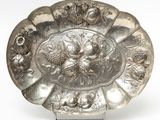 a silver plate with a design on it on a stand