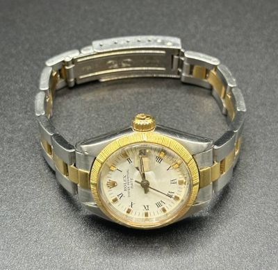 a silver and gold wrist watch on a table