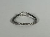 a close up of a silver bracelet on a white surface