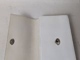 a white book with a hole in it on a table