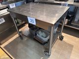 une table en acier inoxydable sur laquelle sont disposés plusieurs plats