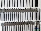 a lot of forks that are lined up on the wall
