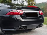 the rear end of a black sports car parked in a parking lot