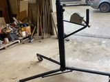 an image of a black metal stand with wheels in a garage