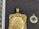 deux pendentifs en or et une bague ornés d’un œil maléfique