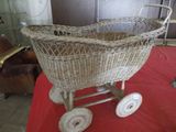 a wicker baby stroller on a red table
