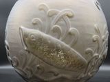 un vase blanc orné d'un poisson, posé sur une table