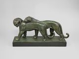 une statue en bronze représentant un lion et une lionne sur un socle
