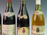 four bottles of wine are lined up on a table