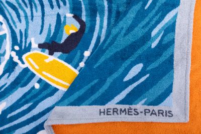 serviette sur laquelle est représenté un surfeur chevauchant une vague sur une planche de surf