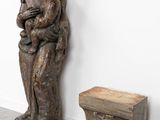 statue of a woman holding a child next to a small box