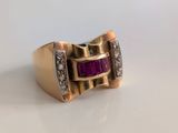 gros plan d'une bague en or avec un rubis et des diamants