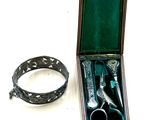 pair of scissors and a ring in a case on a white surface