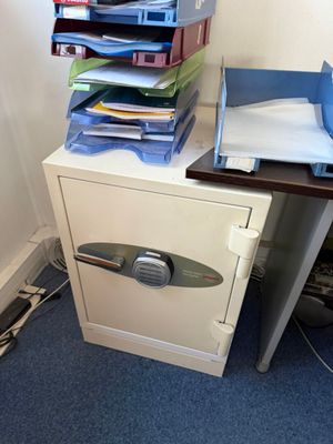 une pile de dossiers posée sur un bureau, à côté d'un classeur