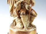 an image of a statue of a man and a woman sitting on a rock