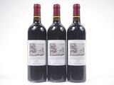 trois bouteilles de vin rouge posées l'une à côté de l'autre sur une surface blanche
