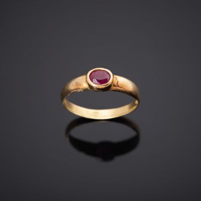 une bague en or avec un rubis au centre