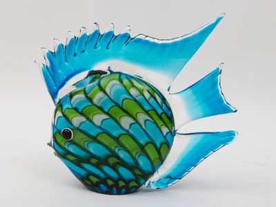 a blue and green fish figurine on a white surface