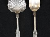 two spoons and a spoon rest on a black surface