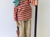 une statue en bois représentant un homme tenant un lampadaire