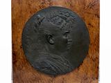 une plaque antique en bronze représentant une femme coiffée d'une couronne
