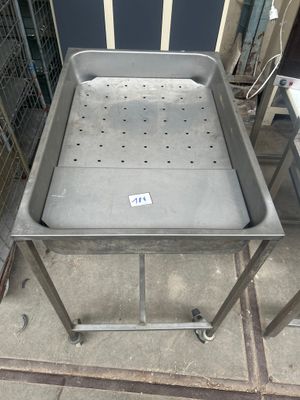 une table en métal sur laquelle est posé un plateau en métal