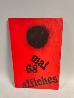 a red book with a black dot on the cover
