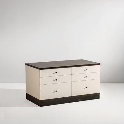 une photo d'une commode blanche et noire posée contre un mur blanc