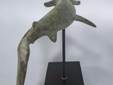 bronze sculpture of a bird on a black stand