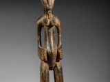 une statue en bois d'un homme avec un chapeau sur la tête
