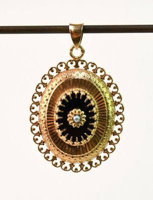 un pendentif en or orné d'un motif noir et or