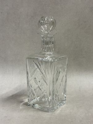 clear glass perfume bottle with a glass stopper on a white background