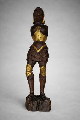 une statue en bois représentant un homme en armure, muni d'une épée