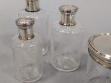 three glass jars with silver lids and a silver lid on a table
