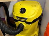 a yellow vacuum that is sitting on the floor next to a laptop