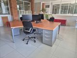 a desk with two computers and a chair in the room