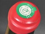 a close up of a bottle of wine with a red cap