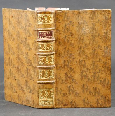 an old book with a golden cover sitting on top of a table